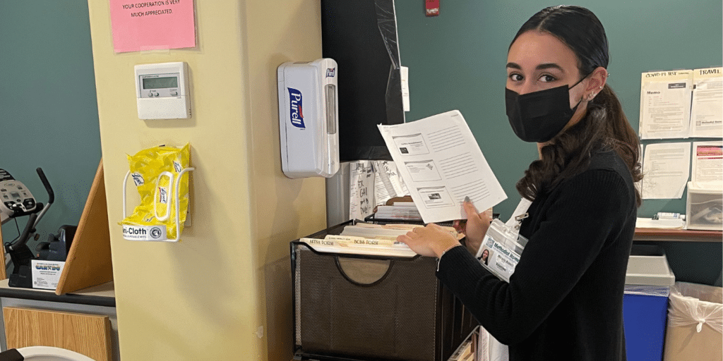 Volunteer filing paperwork in rehab center at non-profit organization