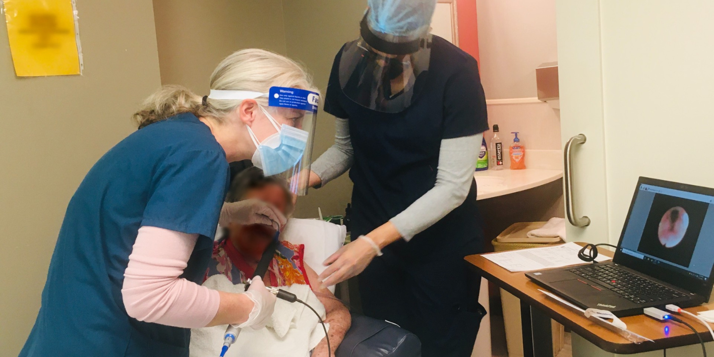 Two speech therapists working with patient to do SLP Testing in patient room