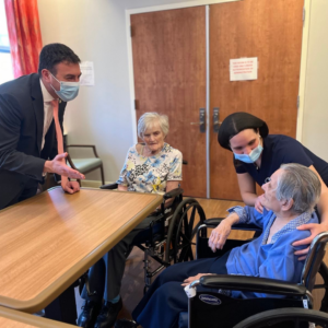 Photo of Councilman Eric Dinowitz meeting with two Methodist Home residents with staff person