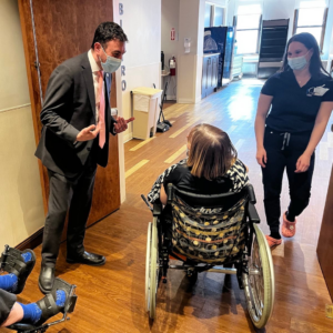 Photo of Citycouncilman Eric Dinowitz talking to a resident with staff member looking on