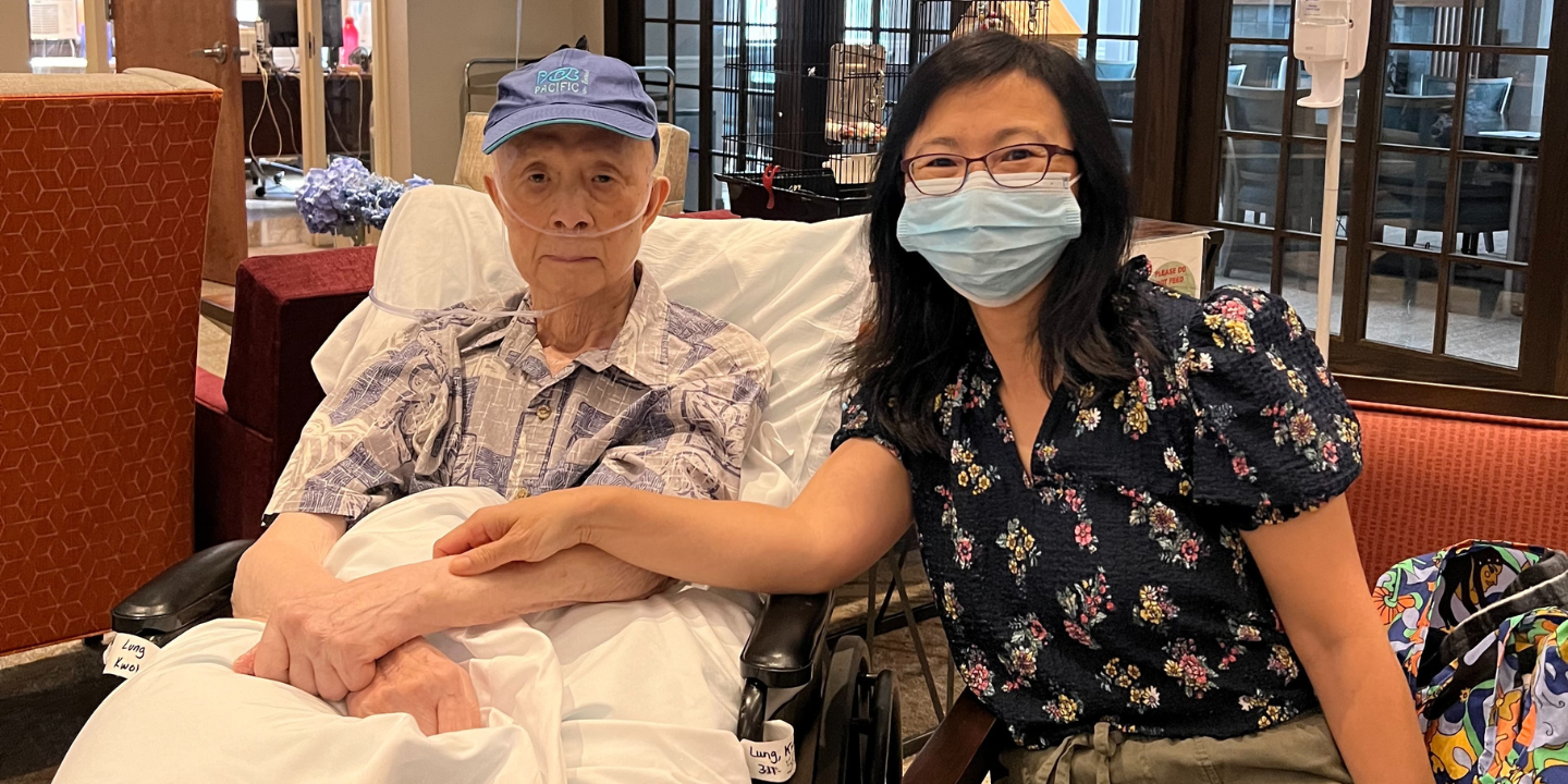 Skilled nursing facility patient sitting in a comfortable common area in a rehabilitaiton facility with his daughter.